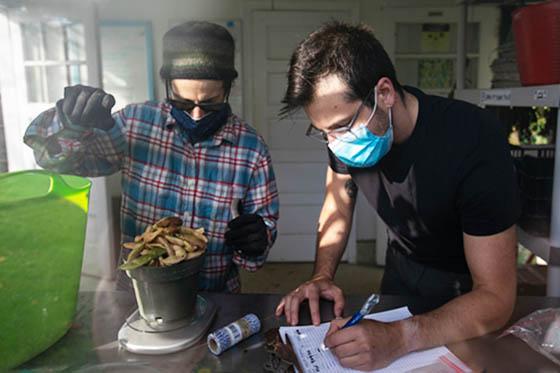 Photo of two masked Chatham University students working in an Eden Hall lab