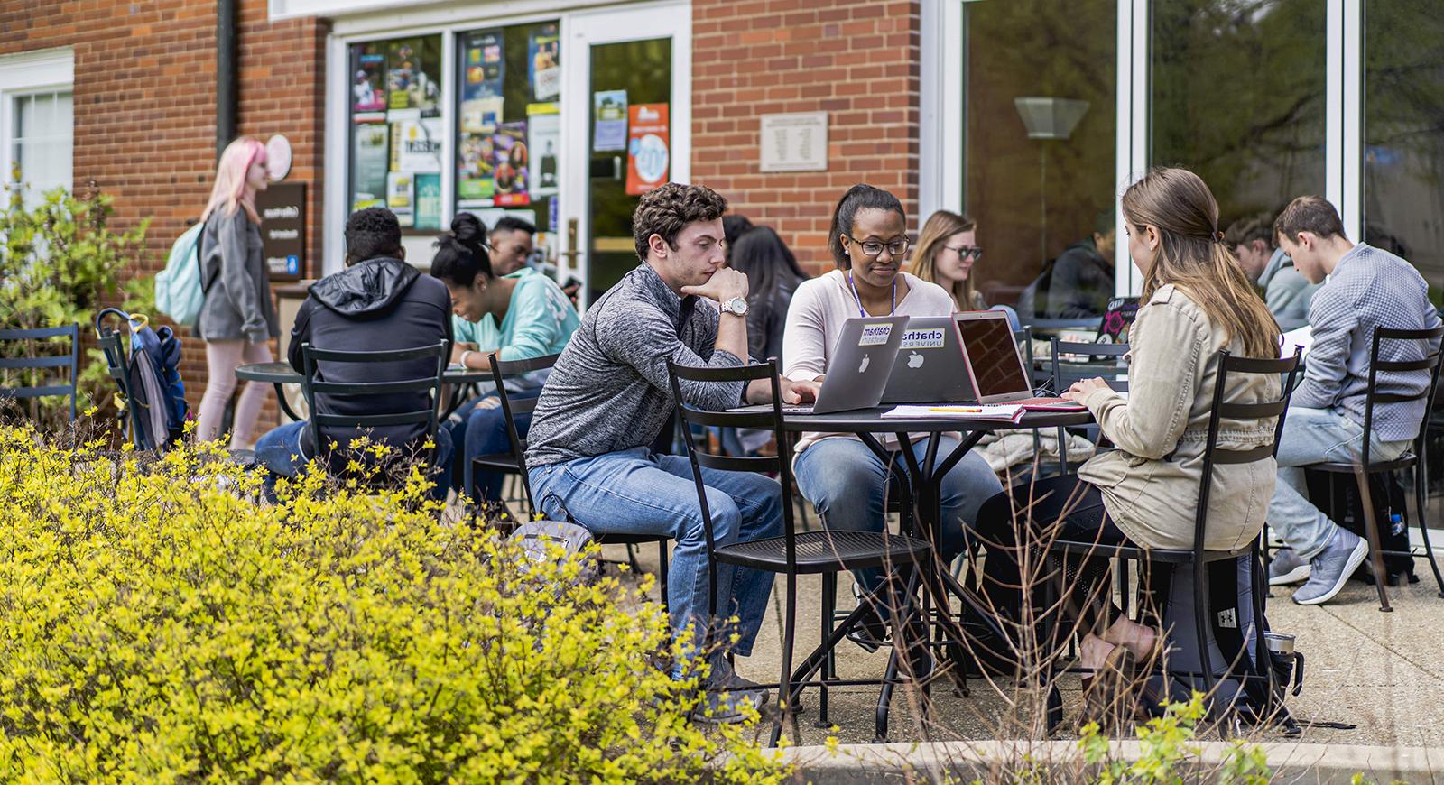 图为波胆网站的学生们在Shadyside校区的Cafe Rachel前的户外露台桌子上工作.