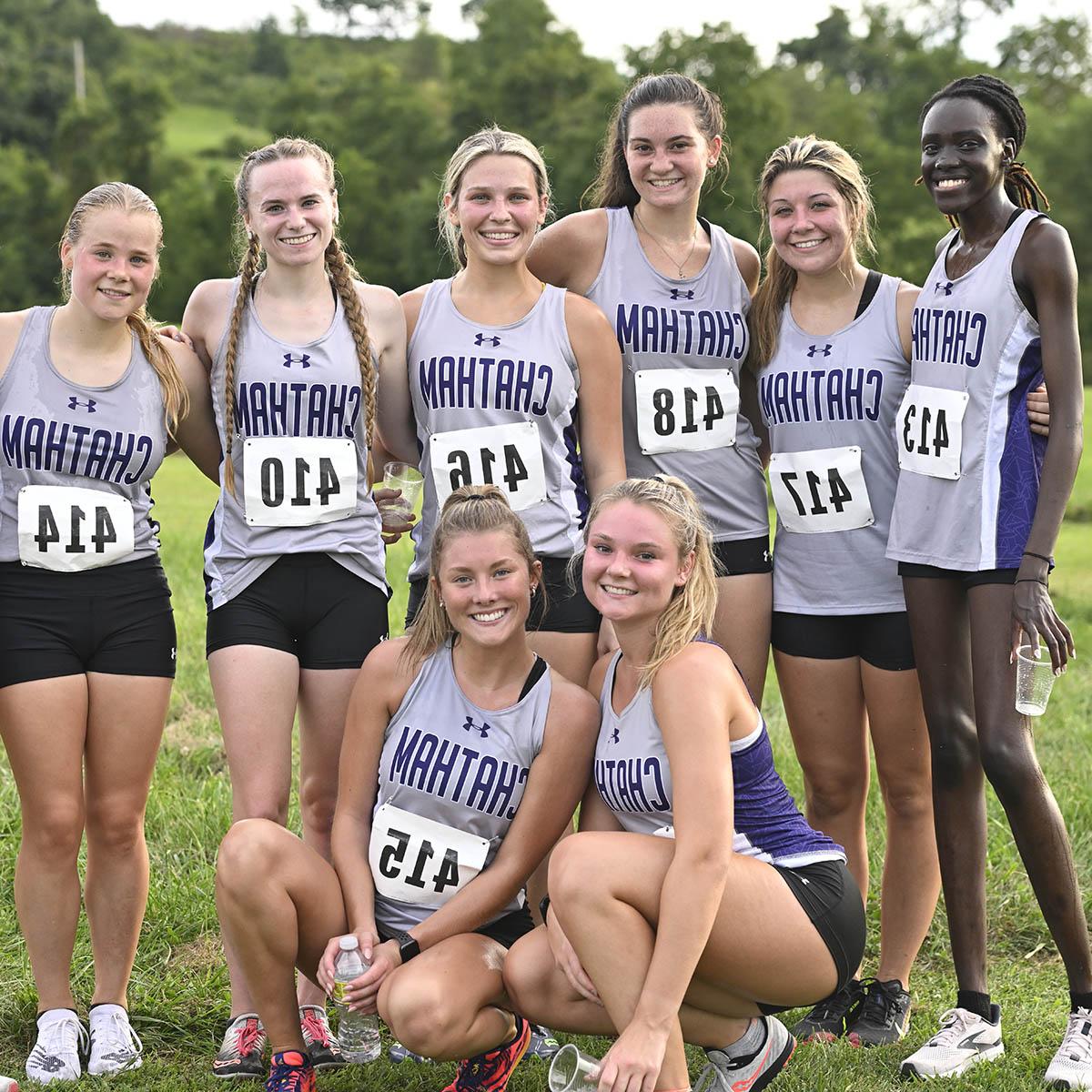 Photo of six young women on the Chatham track team in uniform, smiling for a photo